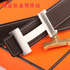 Brown leather belt close-up with gold-tone buckle and white contrast stitching.