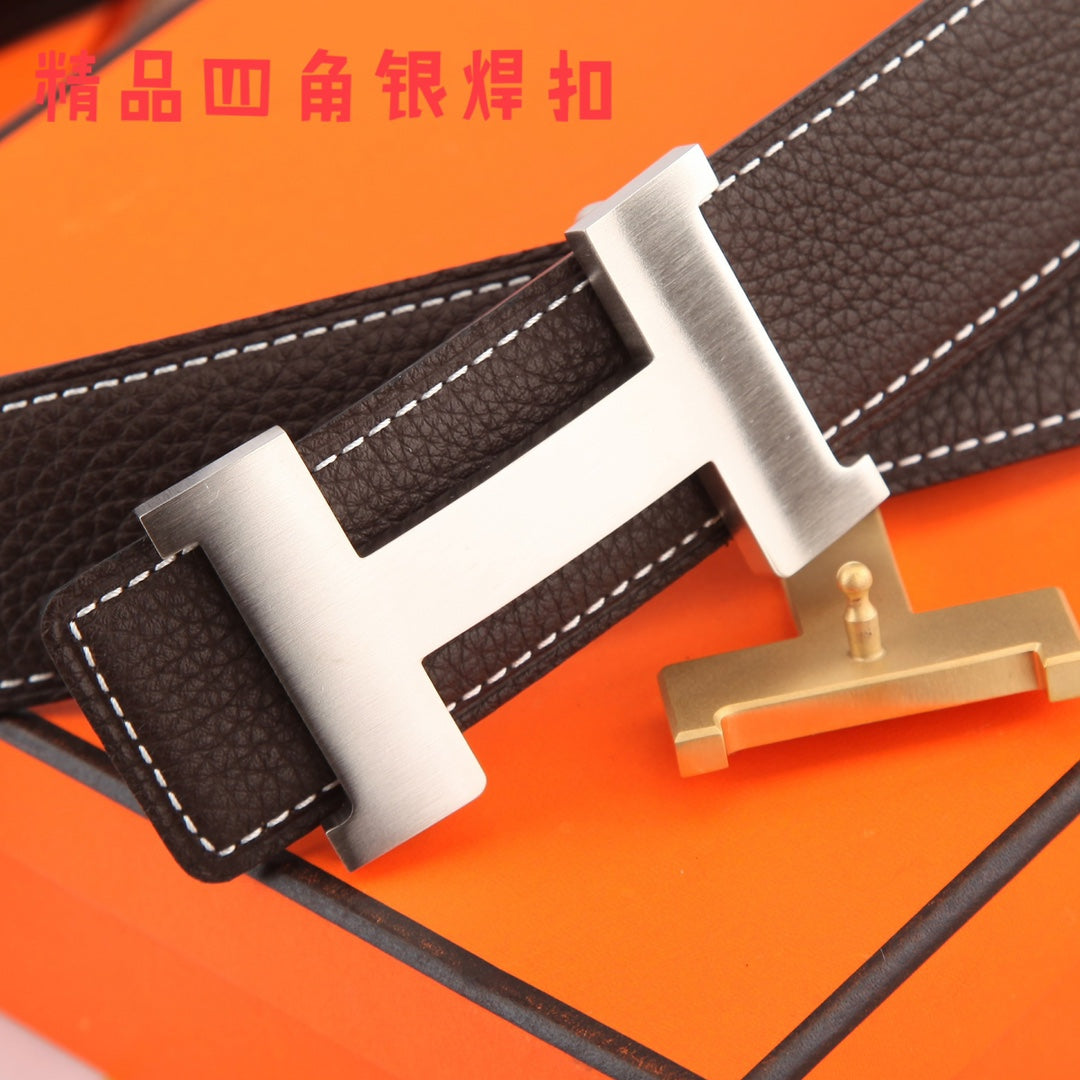Brown leather belt close-up with gold-tone buckle and white contrast stitching.