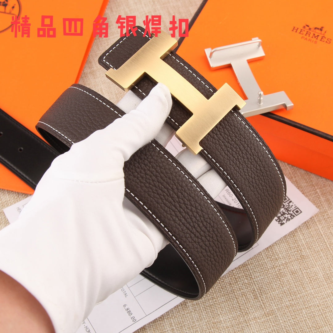 Brown leather belt buckle close-up with gold-tone hardware and white contrast stitching.