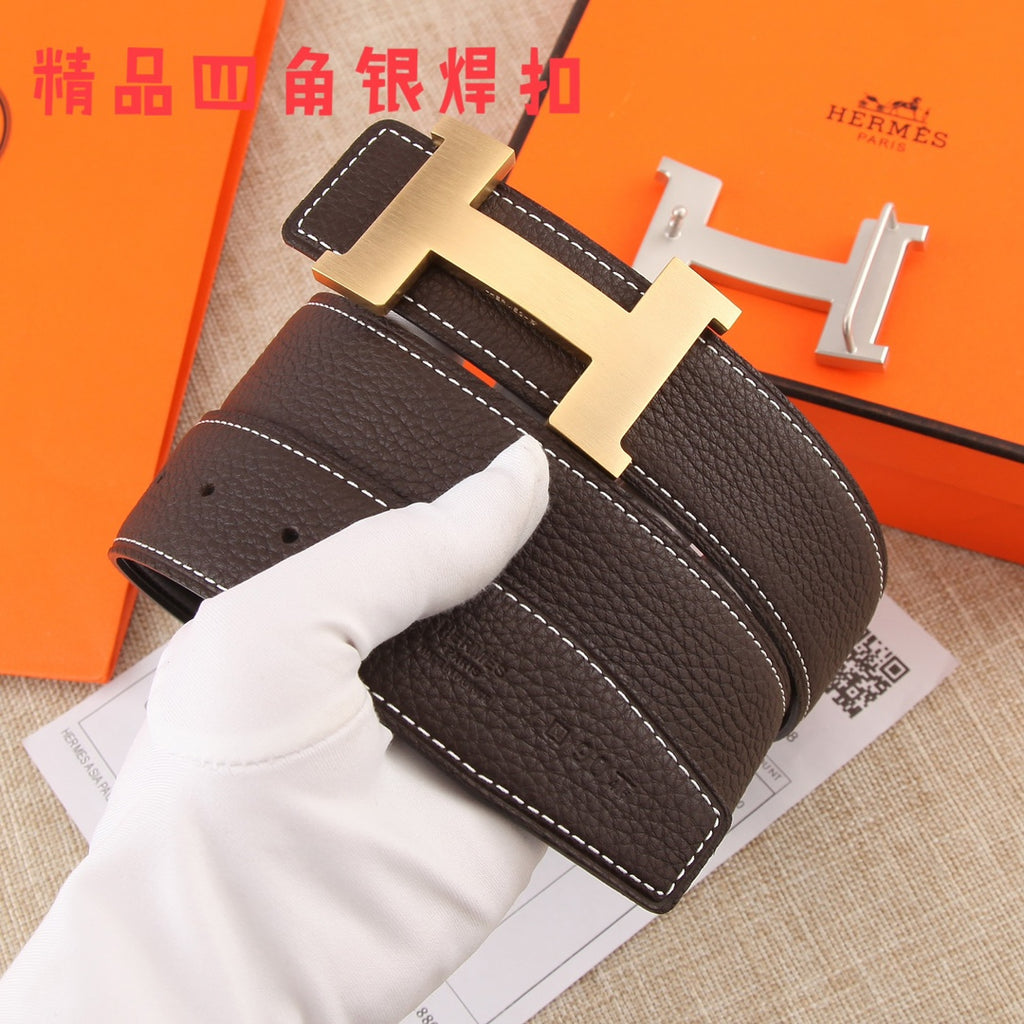 Brown leather belt close-up with gold-tone buckle and white stitching, held by a glove.