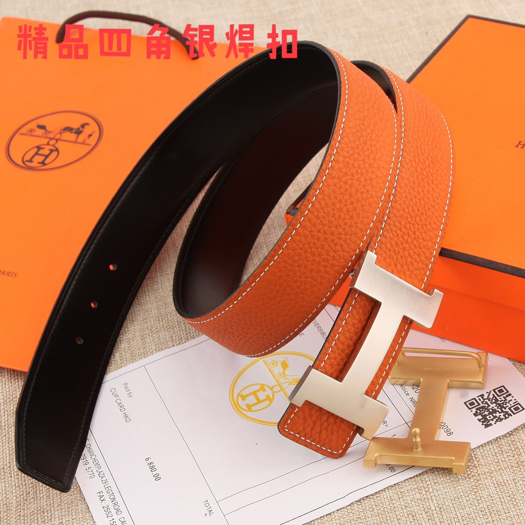 Hermes leather belt with black lining, orange outer strap, silver H buckle