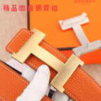 Hermes leather belt close-up: orange grain leather with silver buckle hardware