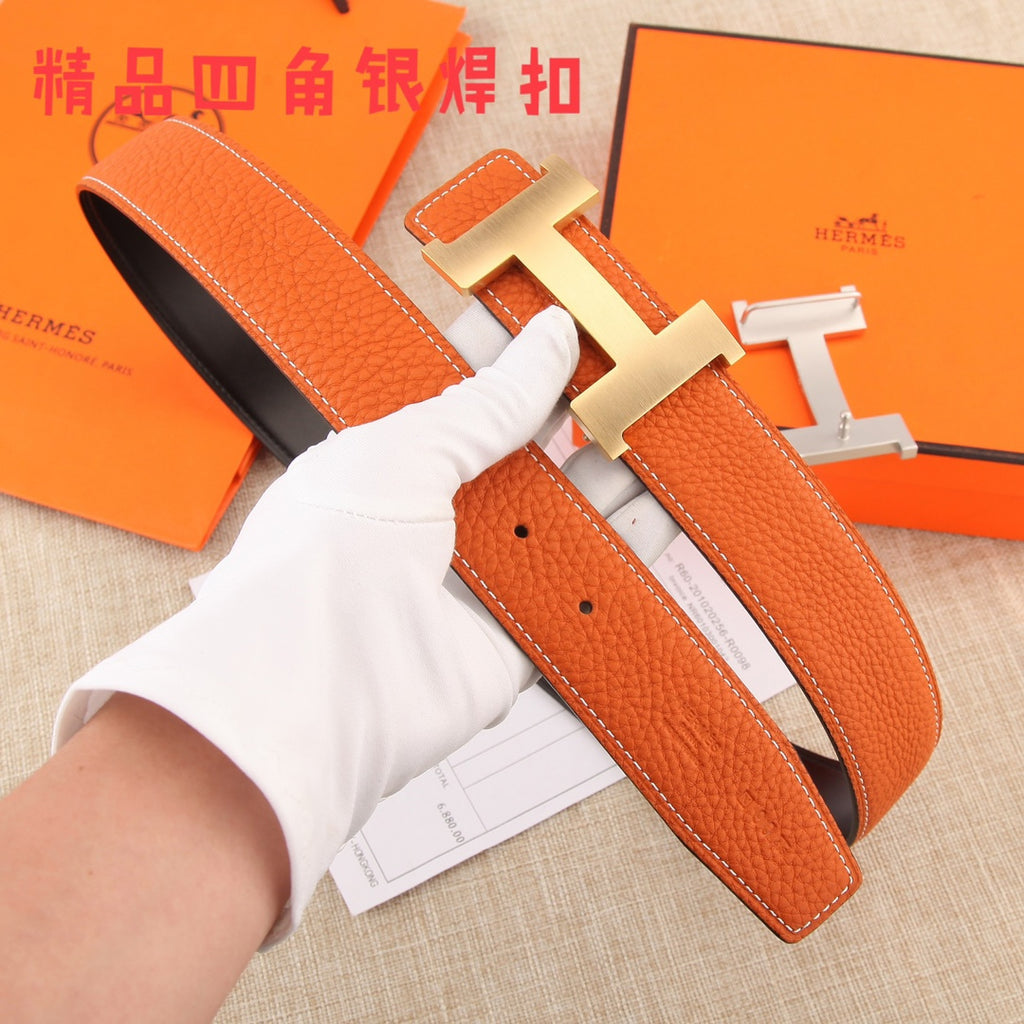 Hermes leather belt with orange strap, silver H buckle, and punched holes