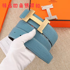 Hermes belt detail: blue strap with white stitching, metal H buckle, hole placement visible