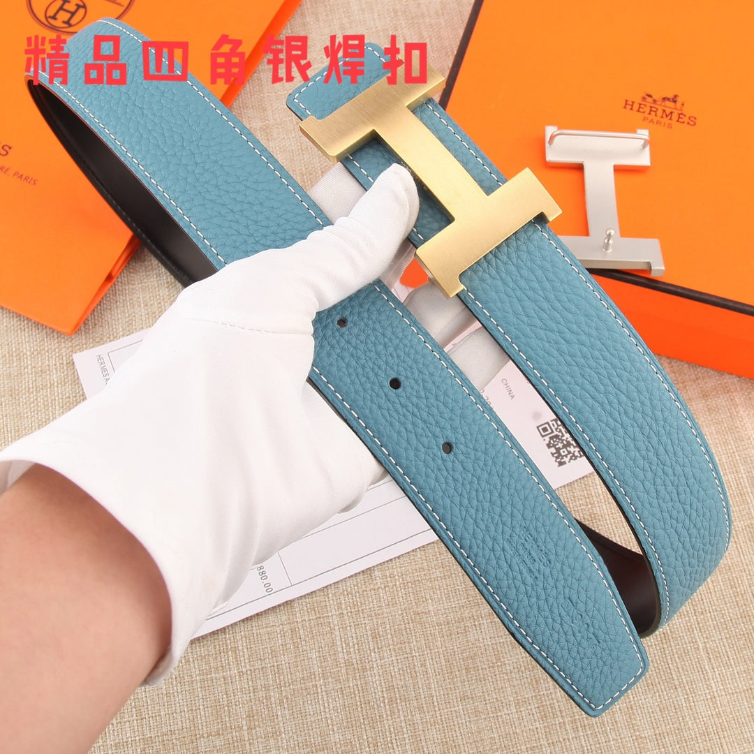 Hermes belt detail: blue leather strap with punched holes, white stitching, metal H buckle