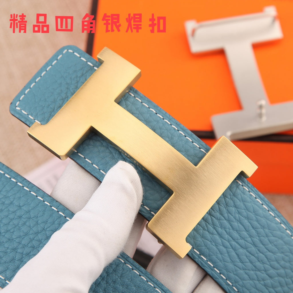 Hermes belt buckle close-up: brushed metal H clasp on blue textured leather strap