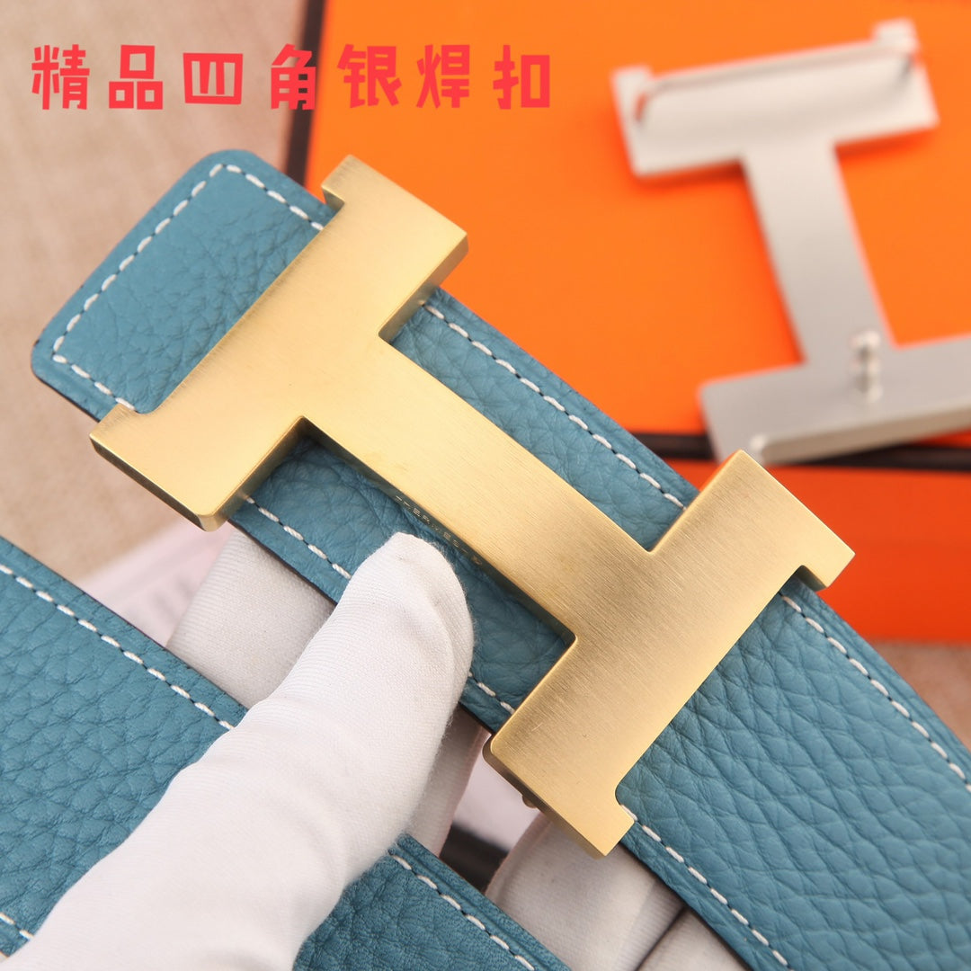 Hermes belt buckle close-up: brushed metal H clasp on blue textured leather strap