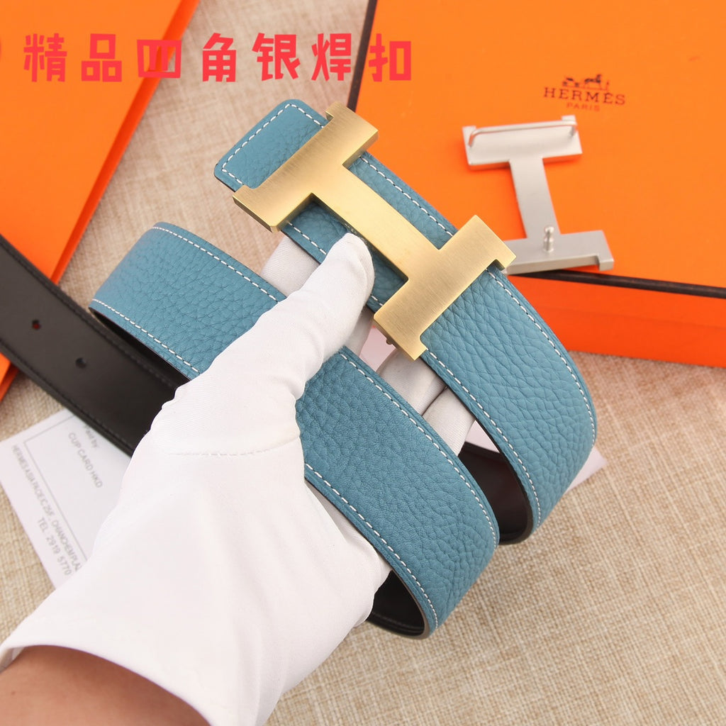 Hermes belt in hand: blue leather strap with white stitching and metal H buckle