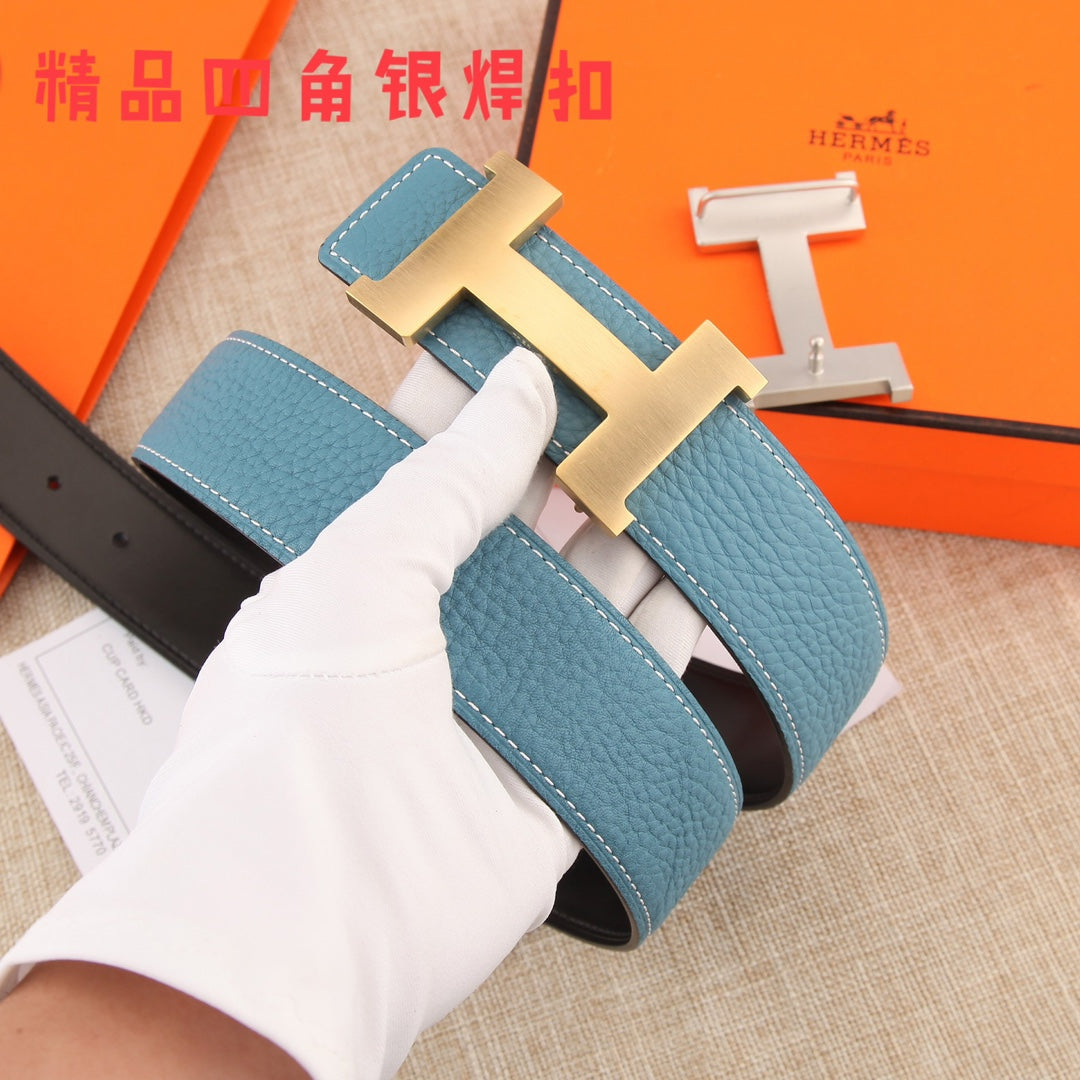Hermes belt in hand: blue leather strap with white stitching and metal H buckle