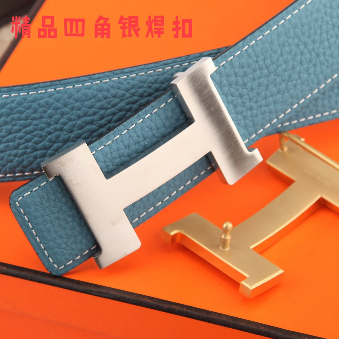 Hermes belt close-up: blue textured strap with white stitching and metal H buckle