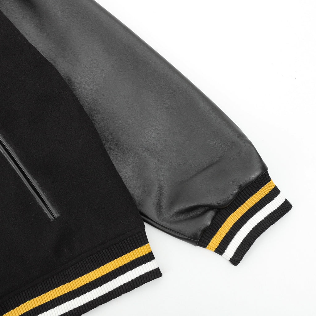 Black jacket sleeve with zipper detail and ribbed stripe cuff in white and yellow