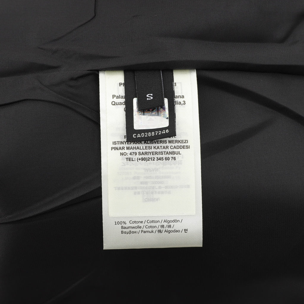 Black jacket care label tag showing 100% cotton and size details