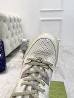 Close-up of Gucci sneaker toe and laces; perforated leather with beige trim