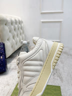Gucci unisex sneakers side view, white leather-look with tan rubber sole tread