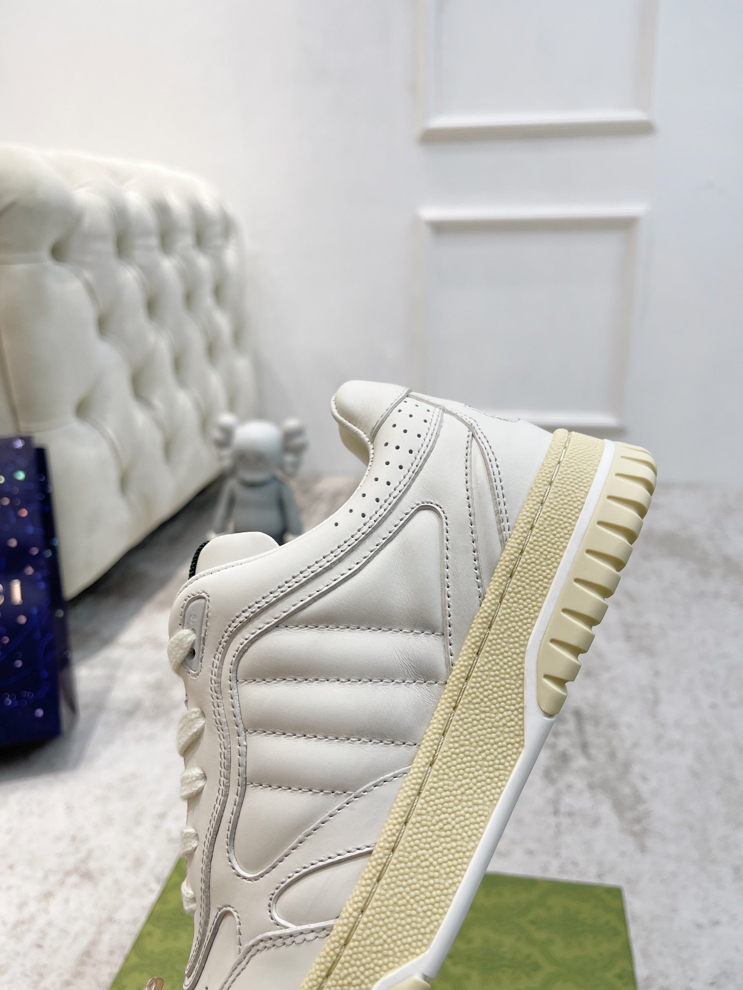 Gucci unisex sneakers side view, white leather-look with tan rubber sole tread