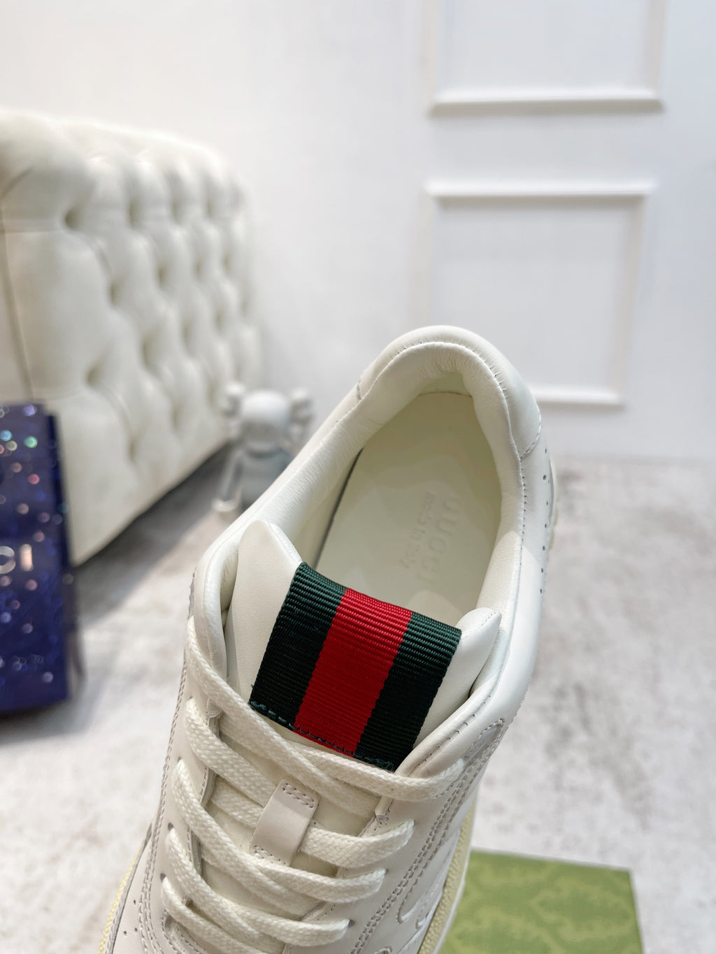 Gucci unisex sneaker upper close-up, white inside with red-green web strap detail
