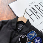 Black bomber jacket neckline close-up with ribbed collar and patches