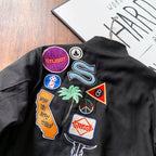 Black bomber jacket back close-up with colorful embroidered patches