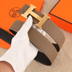 Hermes belt detail: textured brown leather with stitched edges and gold-tone H buckle