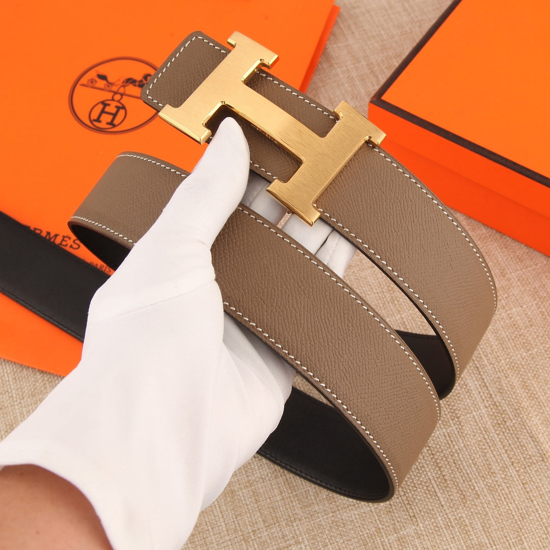 Hermes belt detail: textured brown leather with stitched edges and gold-tone H buckle