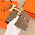 Hermes belt end detail: textured brown leather strap with gold-tone H buckle and edge stitching
