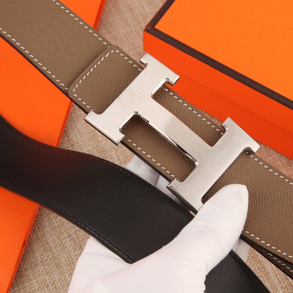 Hermes belt close-up: silver-tone H buckle on textured brown leather with contrast stitching