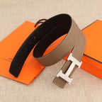 Hermes belt with tan outer strap and dark inner lining, silver-tone H buckle at center