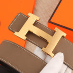Hermes belt close-up of gold-tone H buckle on textured brown leather strap