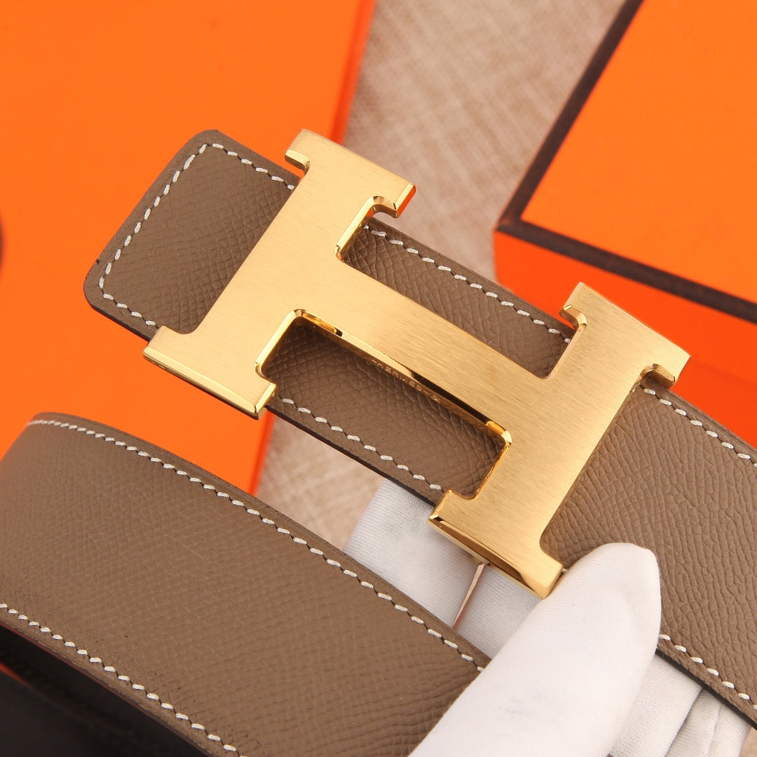 Hermes belt close-up of gold-tone H buckle on textured brown leather strap