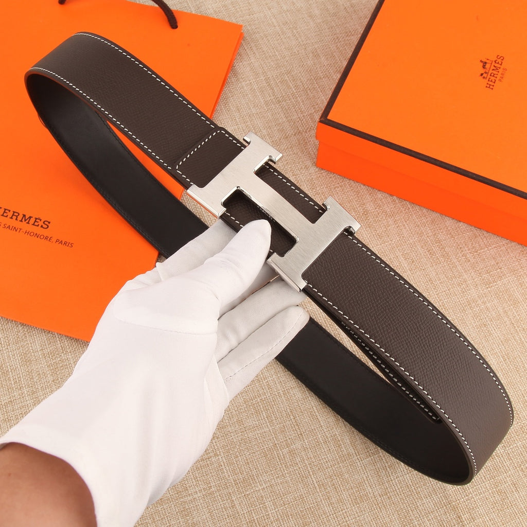 Hermes leather belt with dark brown strap and gold-tone H buckle, white contrast stitching