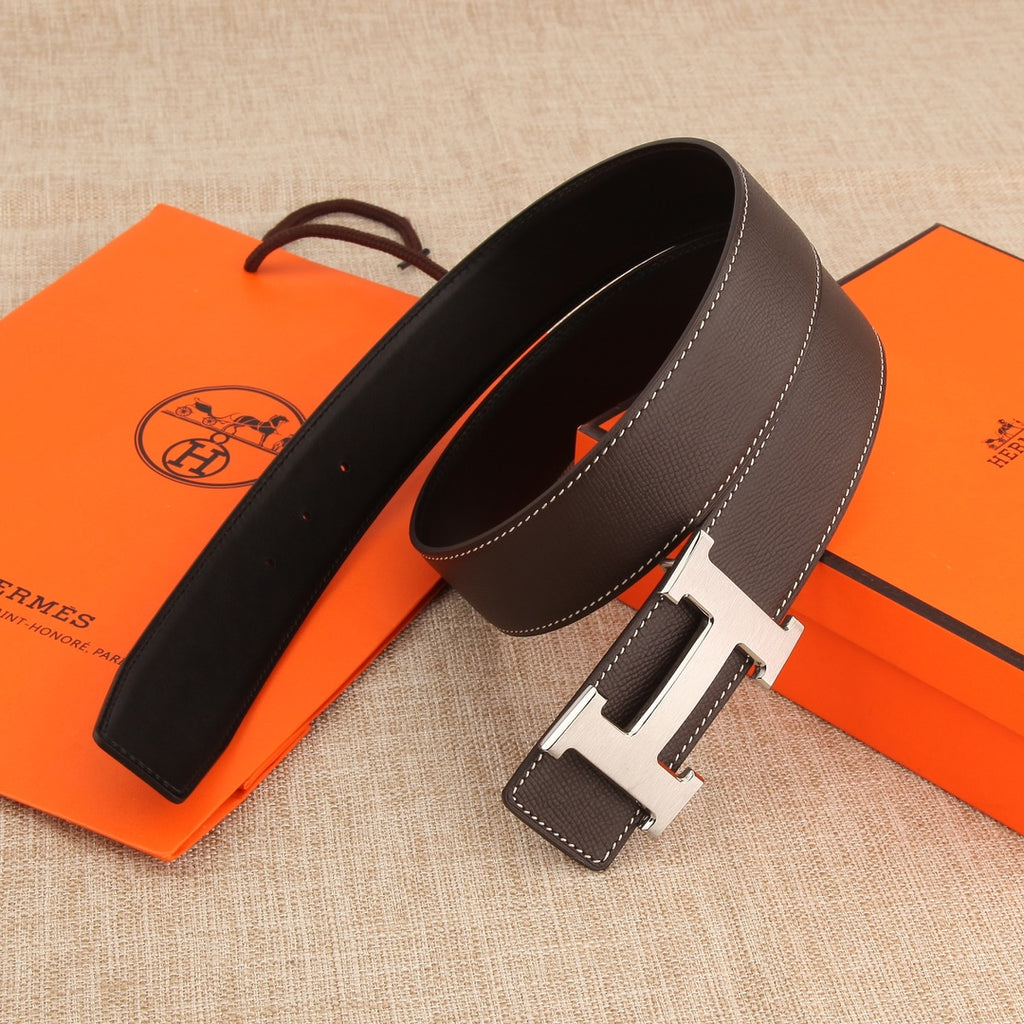 Dark leather belt with gold H buckle and two strap ends, contrast white stitching