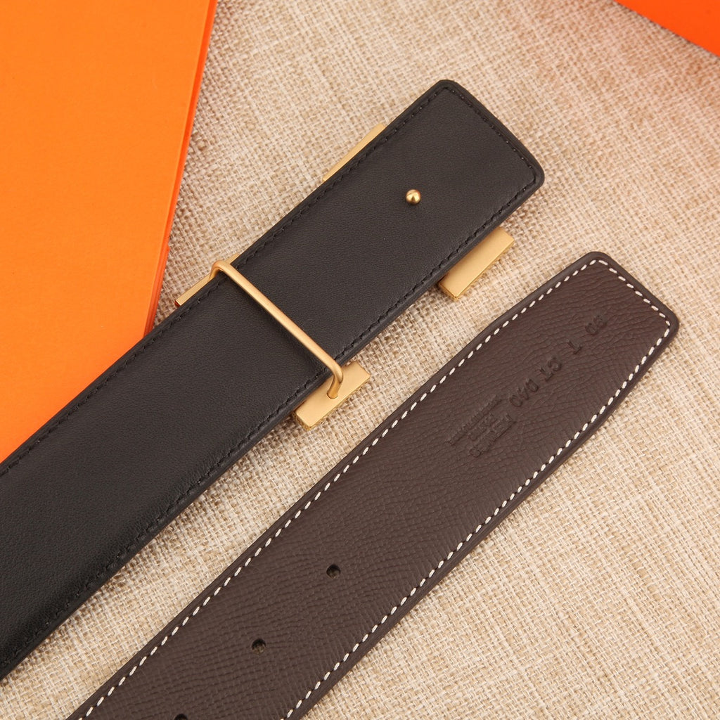 Leather belt with gold-tone buckle and dark strap with rows of adjustment holes