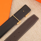 Leather belt with gold-tone buckle and dark strap with rows of adjustment holes