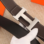 Dark leather belt strap with gold-tone H buckle and white contrast stitching