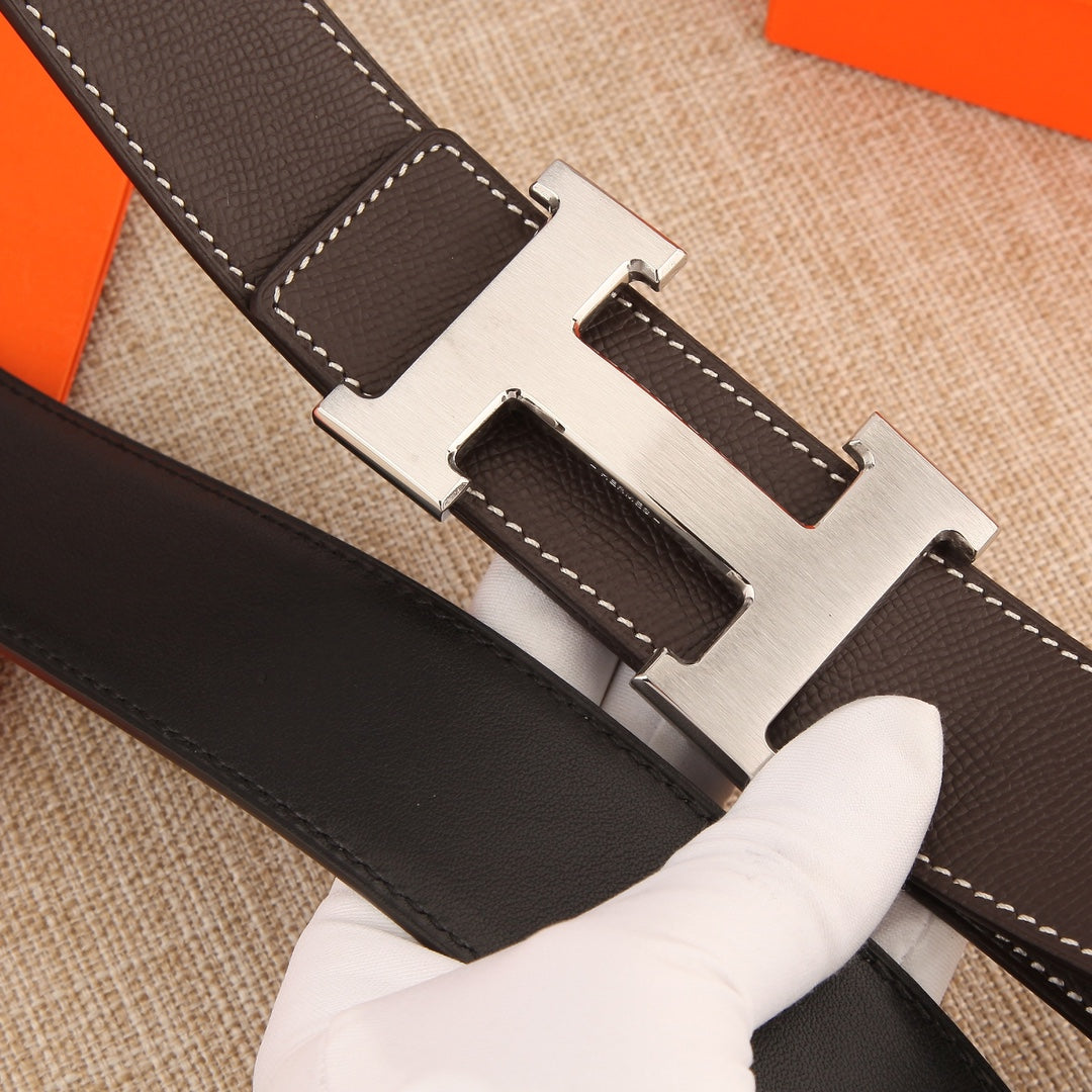 Dark leather belt strap with gold-tone H buckle and white contrast stitching