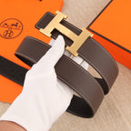 Dark leather belt with gold H buckle and white contrast stitching, adjustable holes