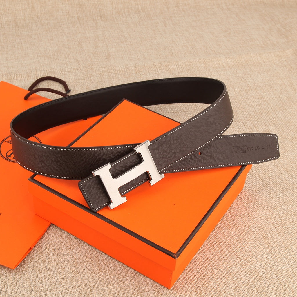 Leather belt with gold-tone H buckle, rectangular keeper, and white contrast stitching