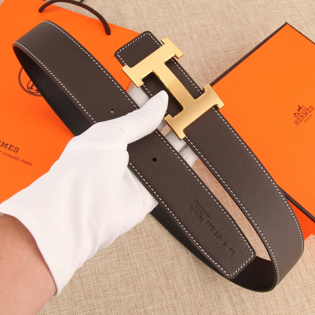 Dark leather belt with gold H buckle and adjustable strap holes, white stitching