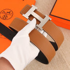 Hermès belt with tan leather strap, silver buckle, and stitched keeper strap