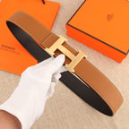 Hermès belt with tan leather strap, silver H-style buckle, and contrast black lining