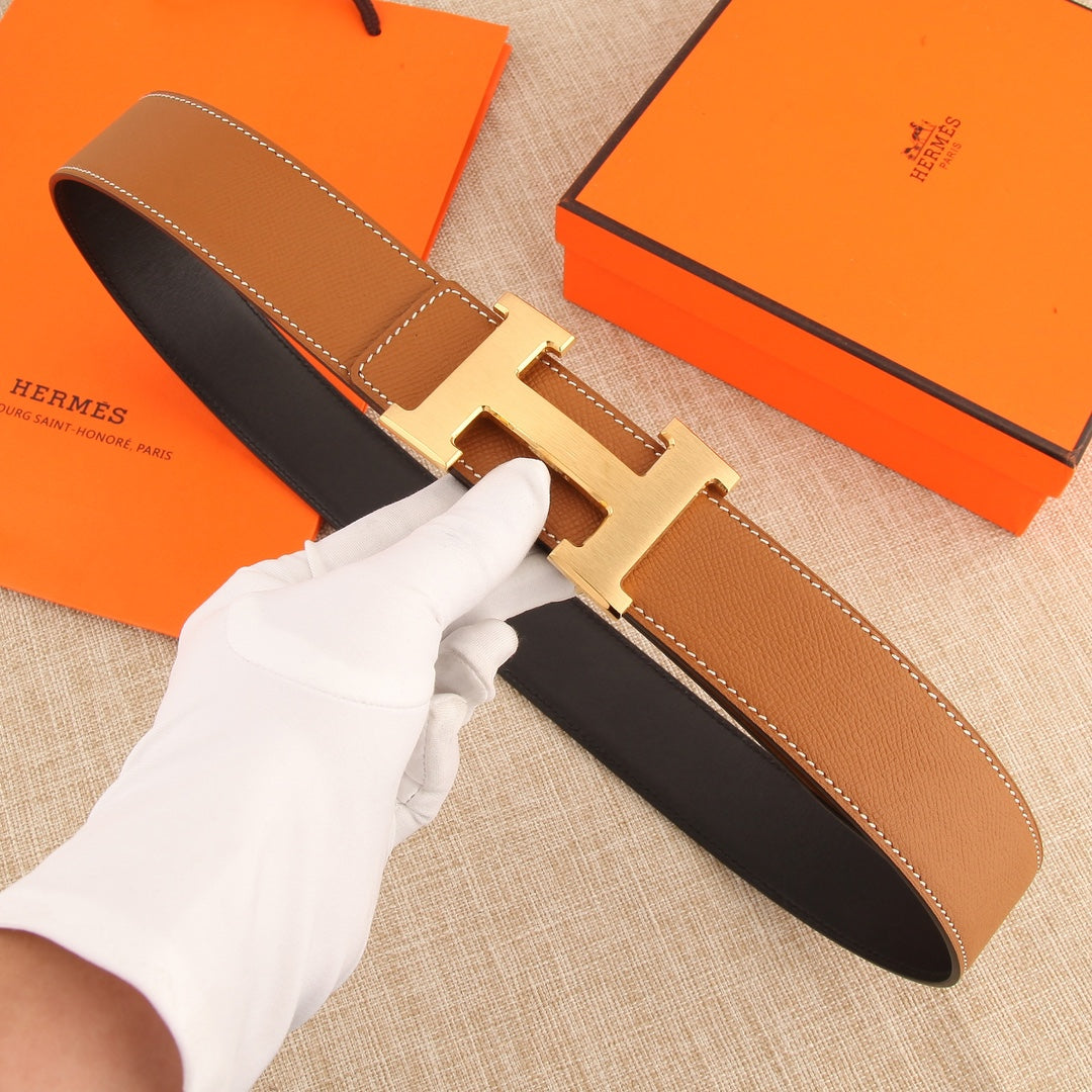 Hermès belt with tan leather strap, silver H-style buckle, and contrast black lining