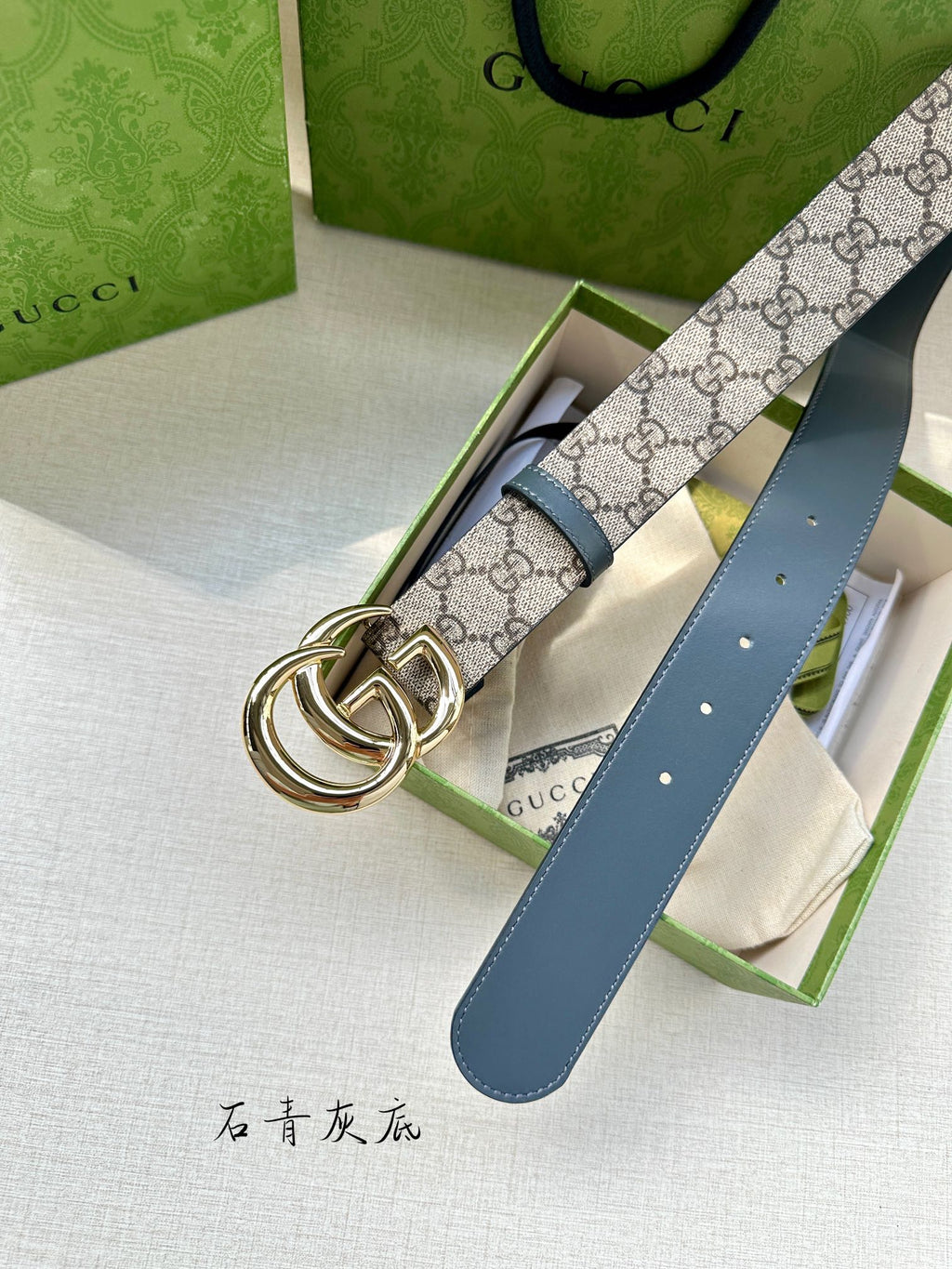 Gucci belt showing double G buckle, blue leather strap, and GG canvas pattern