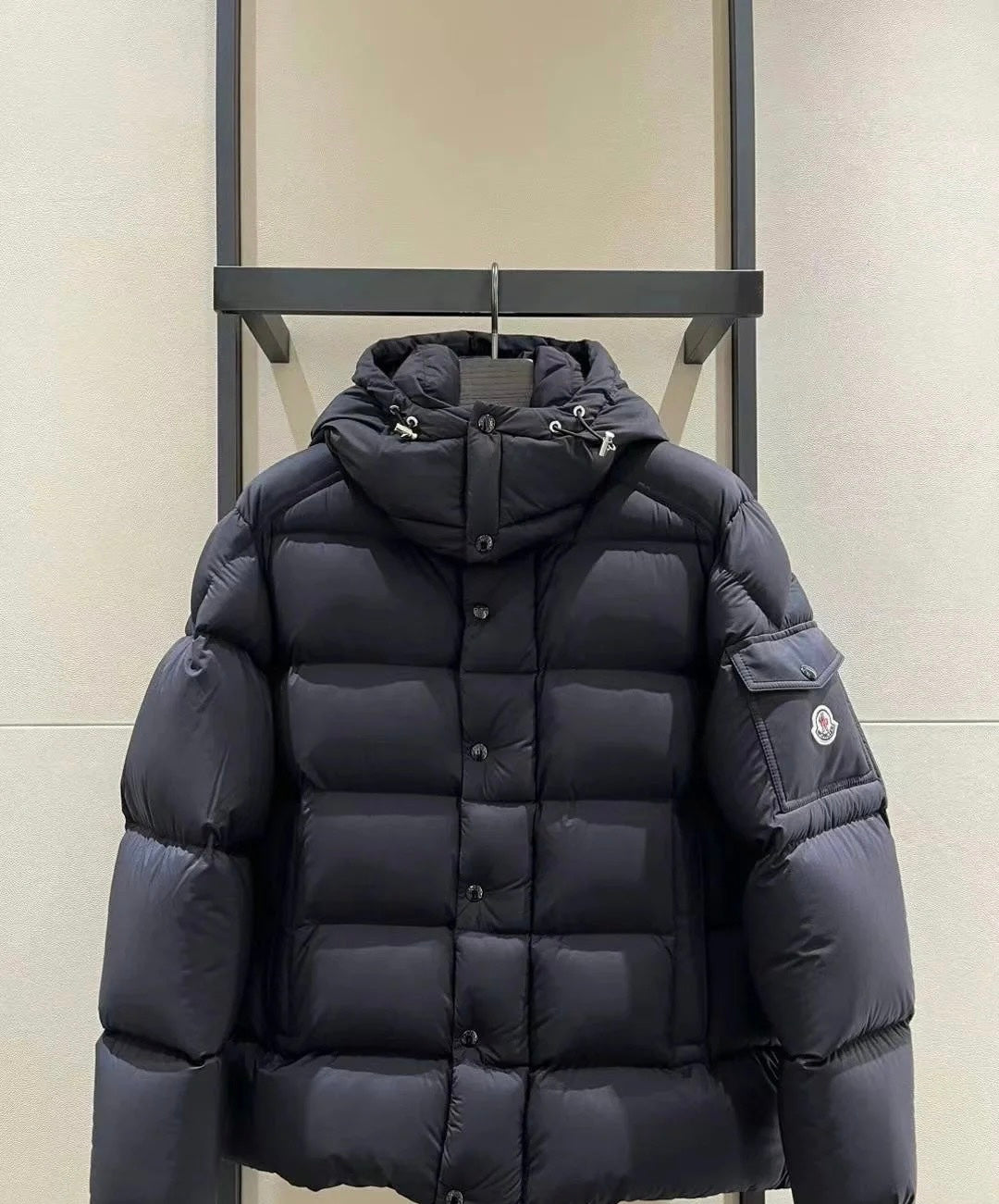 Long puffer jacket in dark color, hood with drawstrings, front zip and buttons