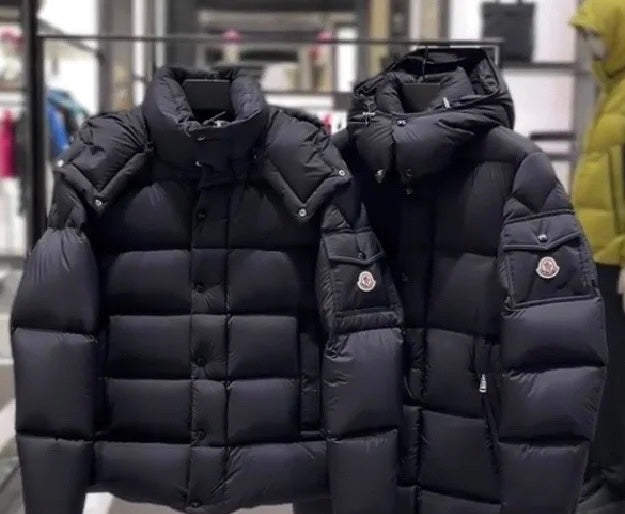Pair of long puffer jackets in dark color, quilted panels and logo sleeve patch