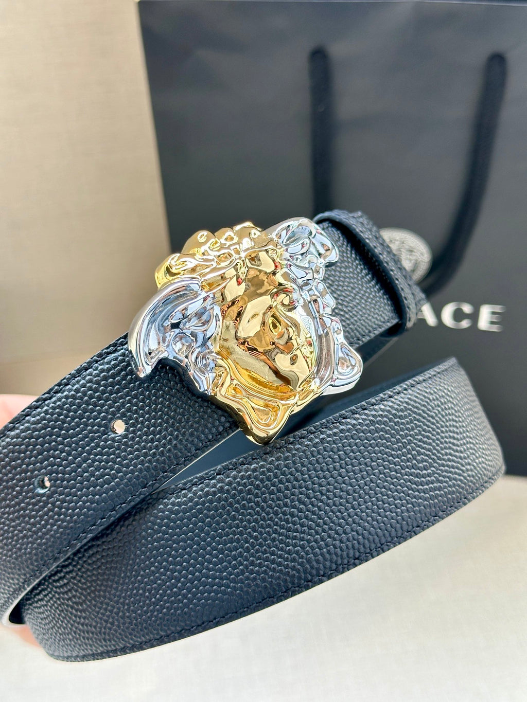 Navy leather belt with Medusa buckle close-up and textured strap