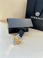 Versace navy belt with Medusa buckle resting on a gift box