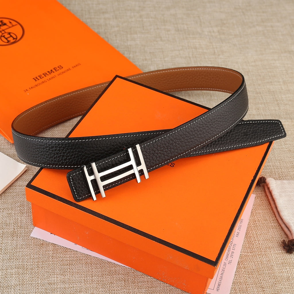 Black leather belt with gold-tone H buckle and contrast white stitching, laid flat