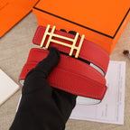 Red leather belt with gold H buckle and white stitched strap, held flat.