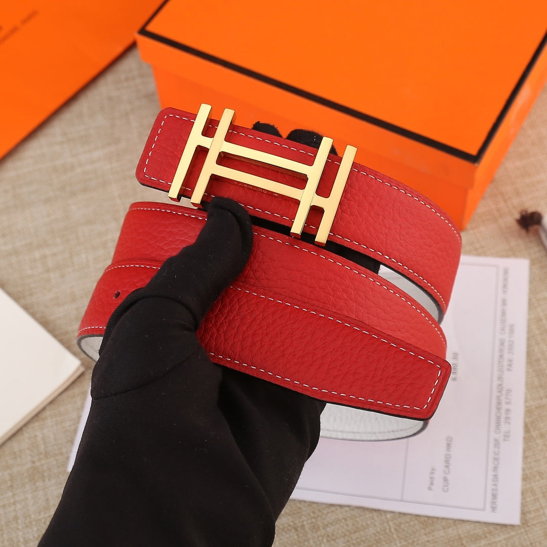 Red leather belt with gold H buckle and white stitched strap, held flat.