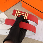 Red leather belt with gold H buckle on a stitched strap, shown top view.